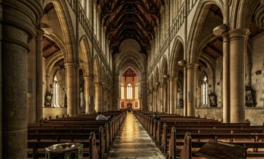 A beautifully detailed interior of a gothic-style historic cathedral with arches and pews.